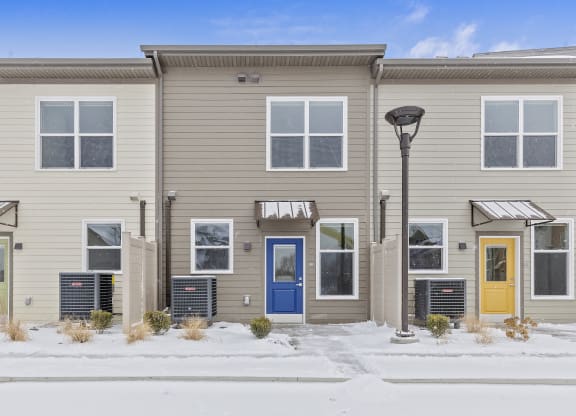 a building with a blue door and a snow covered sidewalk