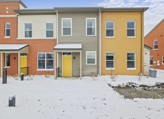 a house with yellow doors in the snow