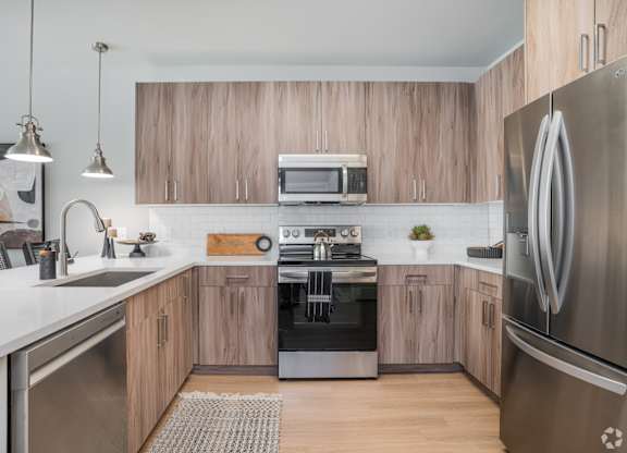 A modern kitchen with wooden cabinets and stainless steel appliances.