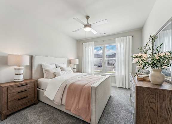 A bedroom with a bed, nightstand, and a plant at The Hendry Apartments, Florida, 33905