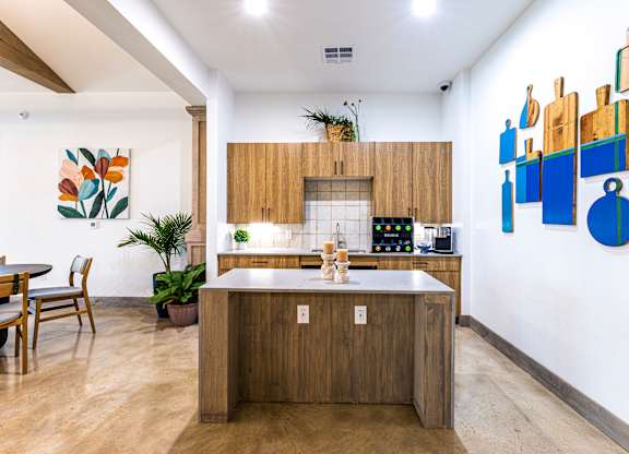a kitchen with wooden cabinets and a marble counter top at The Parker Austin, Pflugerville, 78660