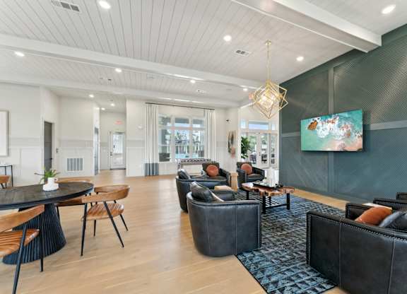 A modern living room with a black couch and a painting on the wall at The Hendry Apartments, Florida, 33905
