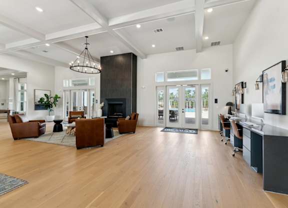 A modern living room with a fireplace and a kitchen area in the background. at The Hendry Apartments, Florida, 33905