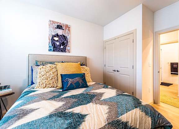 Bedroom with a bed and a door to a bathroom at The Parker Austin, Pflugerville, Texas
