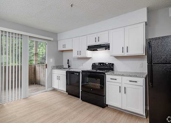 A Kitchen With Black Appliances at Avondale Place Apartments, Avondale Estates, 30002