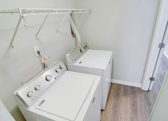 A white washing machine and dryer in a small laundry room.