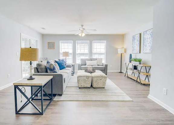 A living room with a white couch, a coffee table, and a rug.