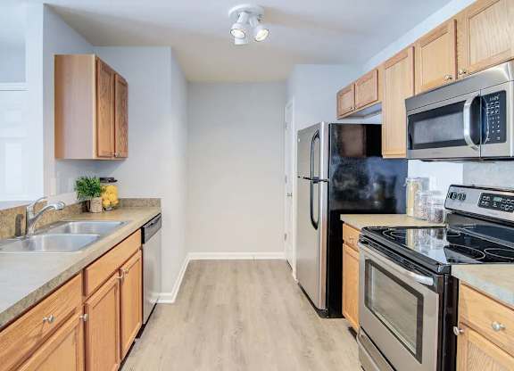 A kitchen with wooden cabinets and stainless steel appliances.