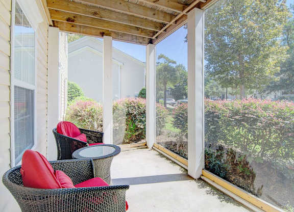 A patio with a table and chairs overlooks a garden.