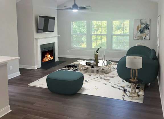 A living room with a fireplace and a green ottoman.