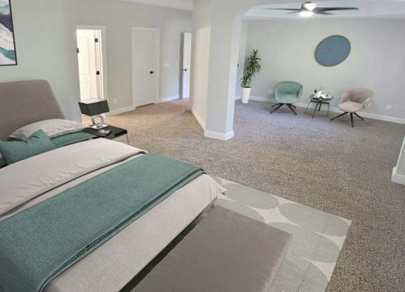 A bedroom with a large bed and a ceiling fan.