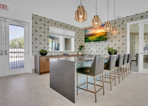 A kitchen with a large island and chairs.