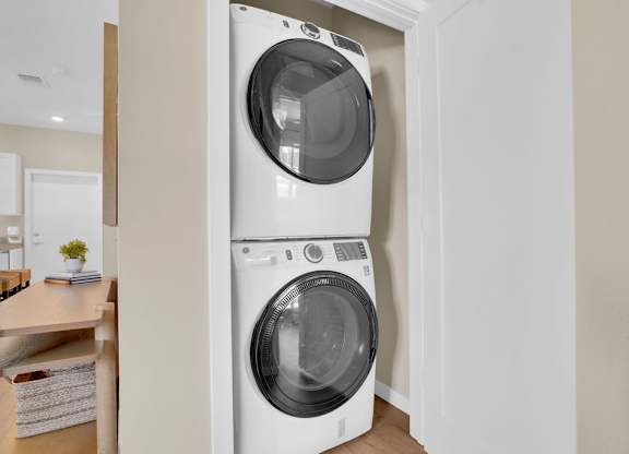 A white washing machine is in a cabinet in a room.