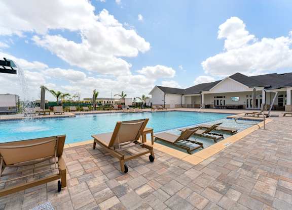 sparkling pool with seating around at The Hendry Apartments, Fort Myers, 33905