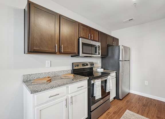 A kitchen with white cabinets and a granite countertop.