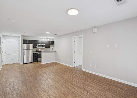 A kitchen with a refrigerator, microwave, and oven is visible.