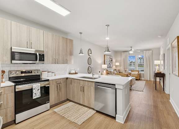 A modern kitchen with wooden cabinets and stainless steel appliances.at The Beacon at 331 Apartments, Santa Rosa Beach, FL