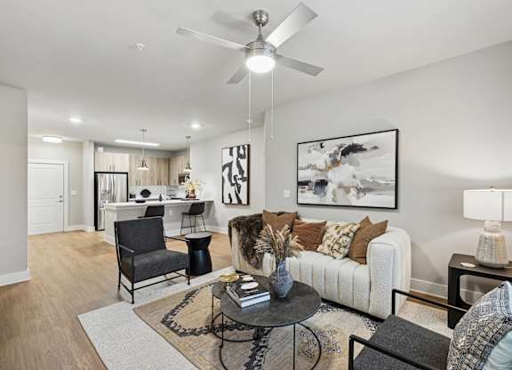 A living room with a white couch, a black chair, and a coffee table. The Beacon at 331 Apartments, Santa Rosa Beach
