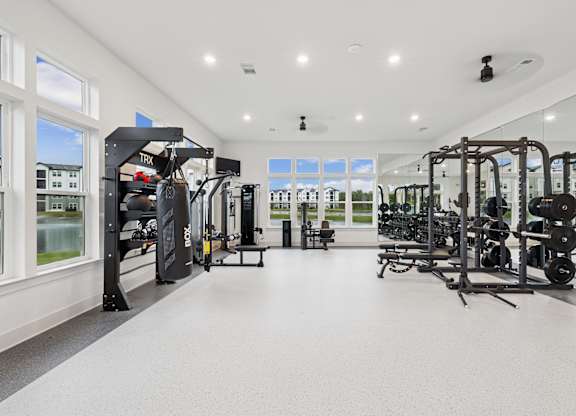 A spacious gym with a variety of equipment and a view of the outside through the windows at The Beacon at 331 Apartments, Santa Rosa Beach, FL