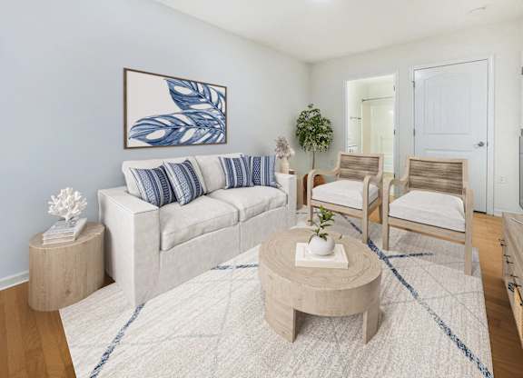 A living room with a white couch, two chairs, and a coffee table.