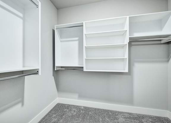 A white pantry with open shelves and a grey carpet at The Ashton at East Park Apartments, Georgia, 30144
