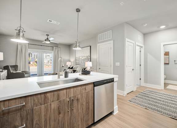 A modern kitchen with wooden cabinets and stainless steel appliances at The Ashton at East Park Apartments, Kennesaw, GA