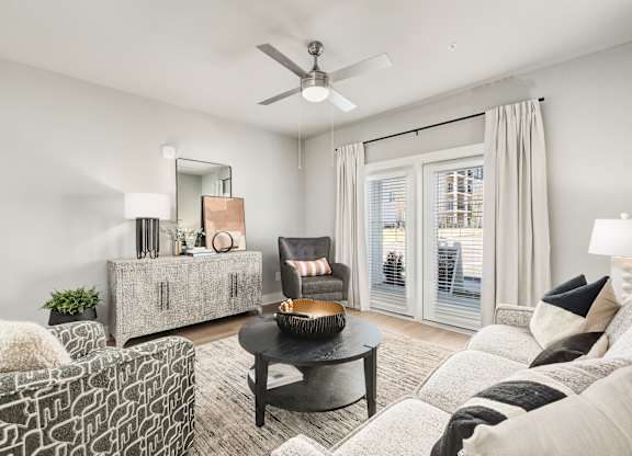 A living room with a black coffee table and a grey sofa at The Ashton at East Park Apartments, Kennesaw, GA, 30144