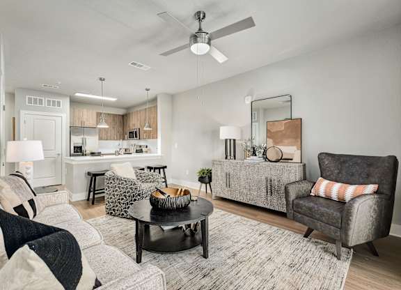 A modern living room with a grey sofa and a black coffee table at The Ashton at East Park Apartments, Kennesaw, Georgia