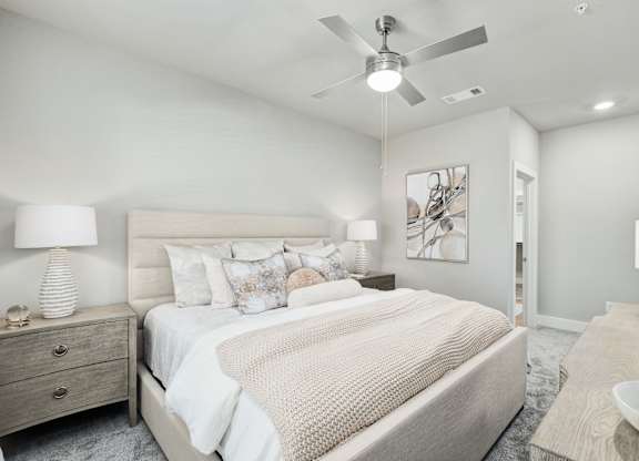 A bedroom with a large bed and a ceiling fan at The Ashton at East Park Apartments, Kennesaw