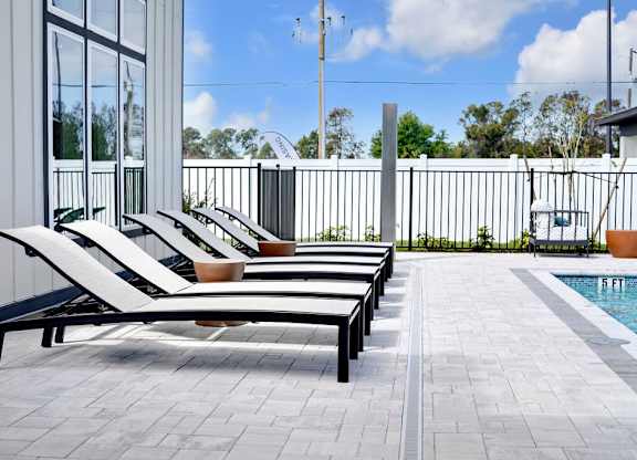 A poolside area with sun loungers and a pool.