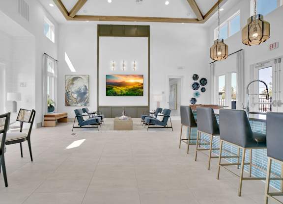 A large room with a painting of a sunset and several chairs.