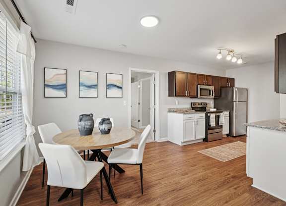 A dining room with a table and chairs.