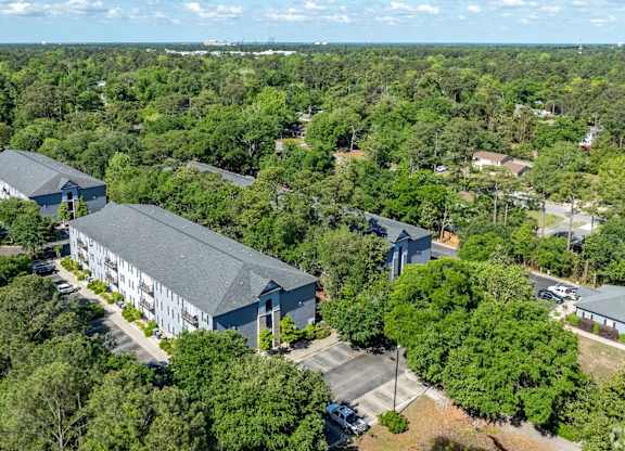 A bird's eye view of a large building surrounded by trees.