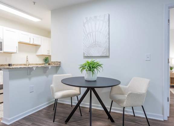 A dining area with a round table and chairs.