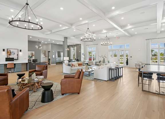 A modern open-concept living space with a kitchen, dining area, and seating options at The Hendry Apartments, Fort Myers, FL