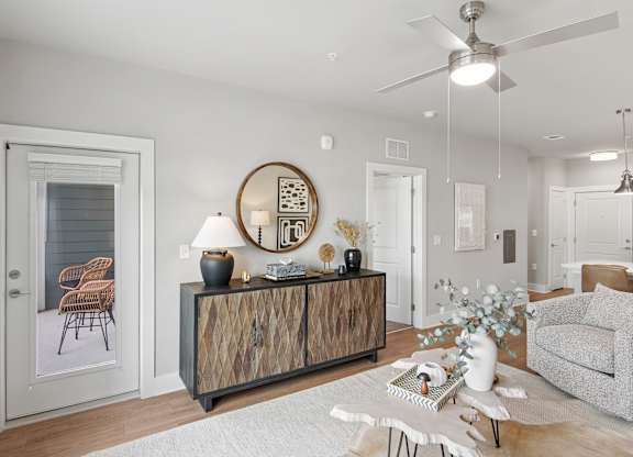 A modern living room with a wooden cabinet and a grey sofa at The Hendry Apartments, Fort Myers, FL