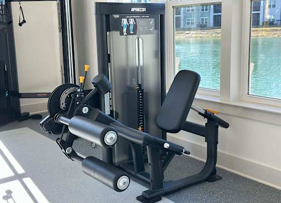 A black and silver gym machine is in front of a window at The Beacon at 331 Apartments, Santa Rosa Beach, FL