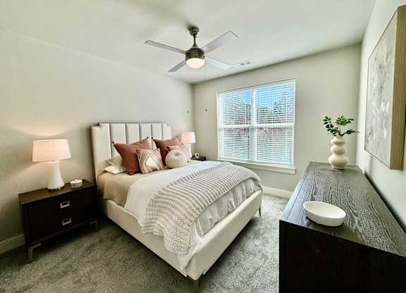 A bedroom with a bed, nightstand, and a ceiling fan at The Collective Upper Westside Apartments, Georgia, 30318