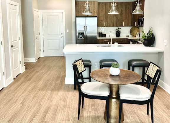 A kitchen with a table and chairs in the middle of the room at The Collective Upper Westside Apartments, Atlanta