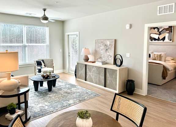 A living room with a grey rug and a black and white painting at The Collective Upper Westside Apartments, Atlanta, 30318