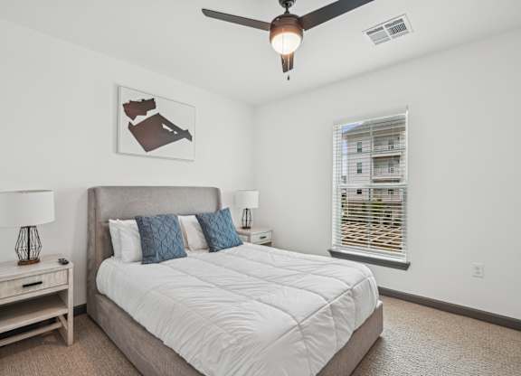 a bedroom with a large bed and a ceiling fan at The Leo Myrtle Beach, Myrtle Beach, SC