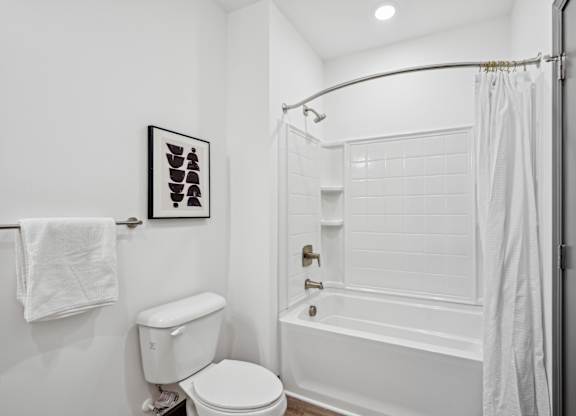 a white bathroom with a shower and a toilet at The Leo Myrtle Beach, South Carolina, 29579