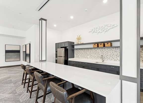 Kitchen with a long counter top and a long island with chairs at The Leo Myrtle Beach, Myrtle Beach, SC