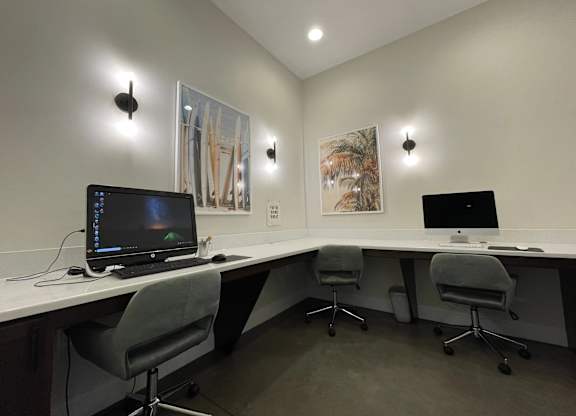 A modern office with two computers and two chairs.