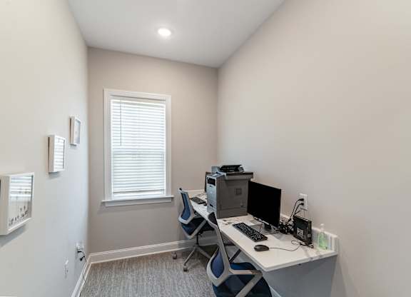 an office with a computer desk and a window