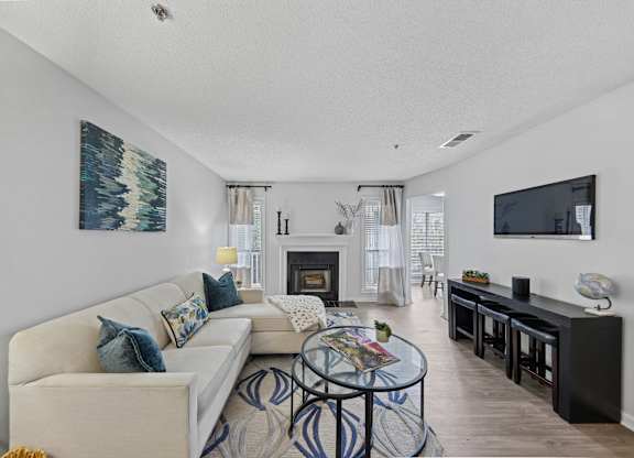 A living room with a fireplace and a painting on the wall.