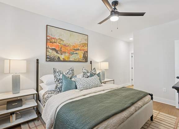 A bedroom with a bed, nightstand, and a painting on the wall at Union Eleven Apartments, Atlanta