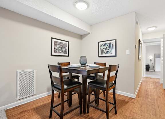 A dining room with a table and chairs.