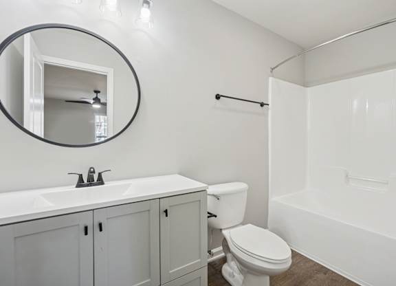 A white bathroom with a toilet, sink, and bathtub.