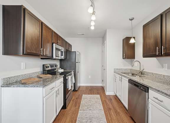 A kitchen with white appliances and brown cabinets.